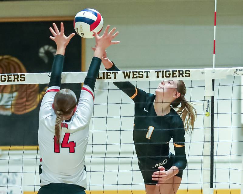 Joliet West's Ava Grevengoed (1) smashes the ball over the the block attempt by Bolingbrook's Sarah Harvey (14) during regional final volleyball match between Bolingbrook at Joliet West.  Oct 26, 2023.