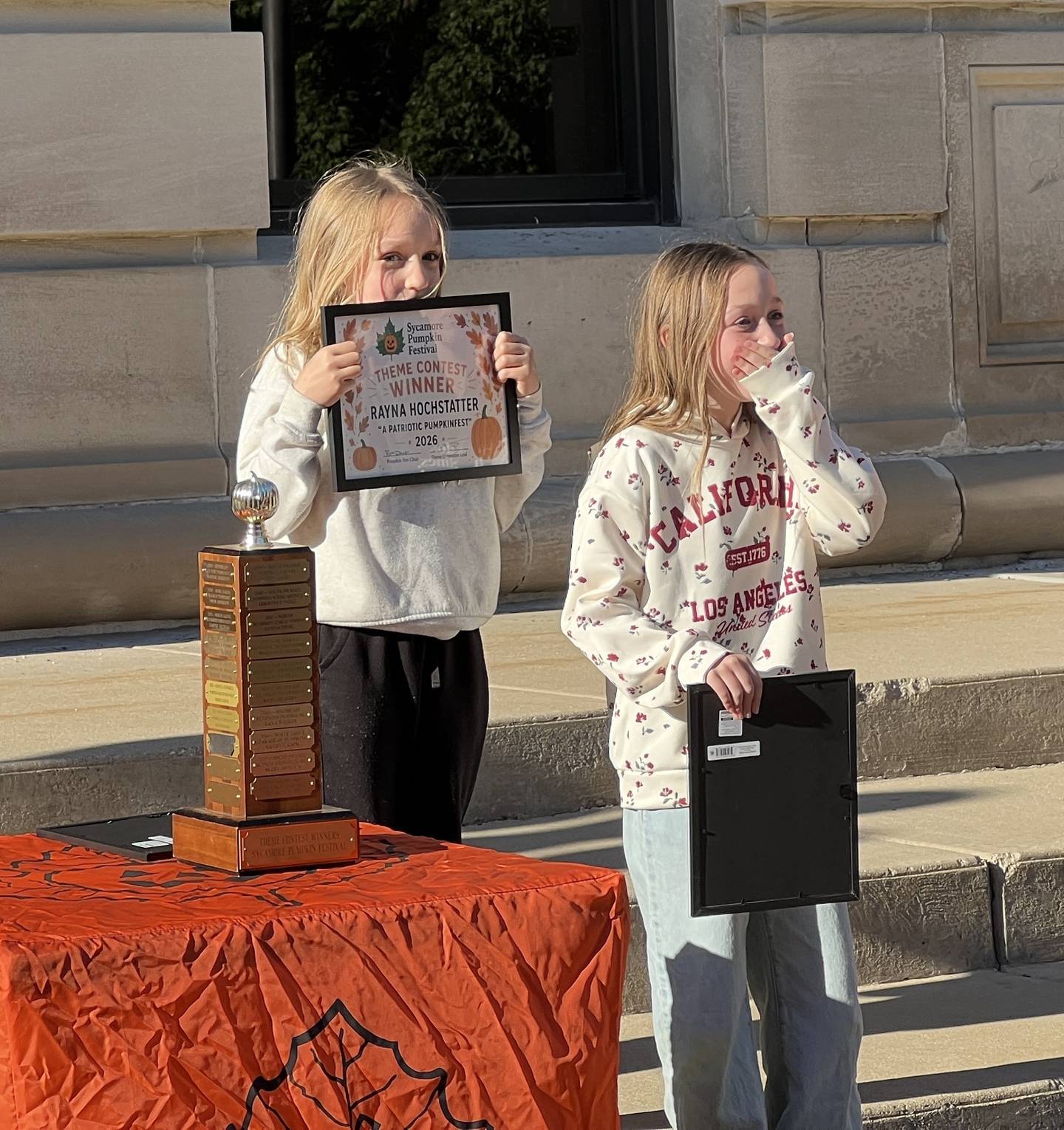 Rayna Hochstatter and her sister, Annabelle Hochstatter, on May 20, 2026, react to being selected as the winner, and one of the runner ups, in the 2026 Sycamore Pumpkin Festival theme contest.