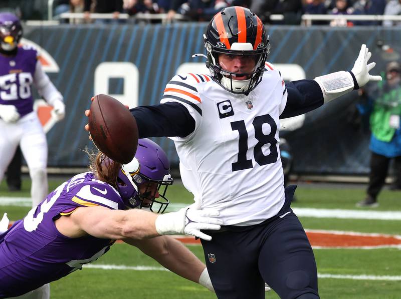Chicago Bears quarterback Caleb Williams reaches to get a first down as Minnesota Vikings linebacker Andrew Van Ginkel tries to make the tackle during their game Sunday, Nov. 24, 2024, at Soldier Field in Chicago.