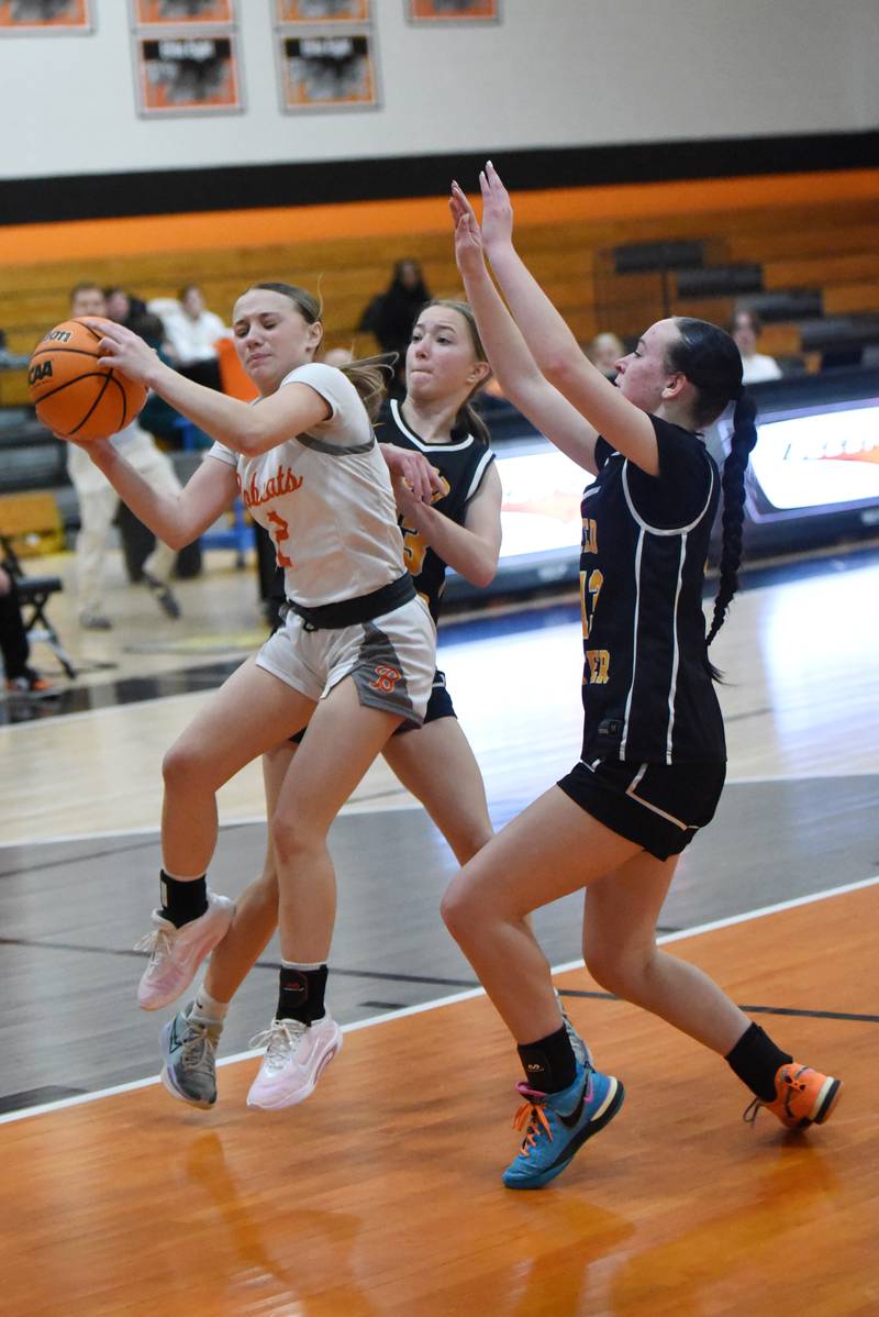 Beecher's Makenna Albert, left, hauls in a rebound in front of Reed-Custer's Avery Vanek, center, and Atiana Hood during a game at Beecher Tuesday, Jan. 20, 2026.