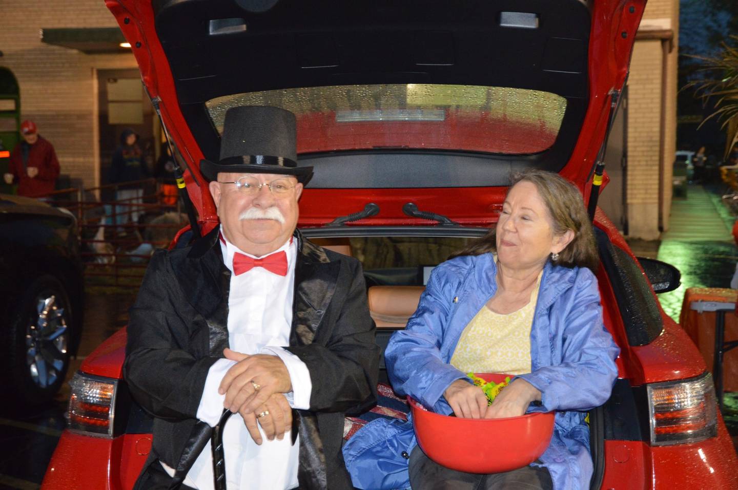 Roy Backus, transitional minister at First Presbyterian Church of Joliet, came out to the church's Trunk 'N Treat event as The Monopoly Man. His wife Ann sits behind him with a bowl of candy to distribute to the trunk-n-treaters. Approximately 800 people braved teeming rain for the Joliet church’s 15th Trunk ‘N Treat event on Oct. 28.