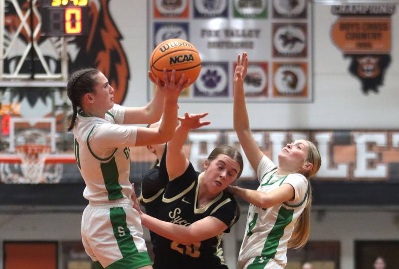 Crystal Lake South’s Mallory Glover, left, and Makena Cleary, right, battle Sycamore’s Callie Countryman for the ball in girls IHSA Class 3A Sectional basketball on Tuesday, Feb. 24, 2026, at Crystal Lake Central High School in Crystal Lake.
