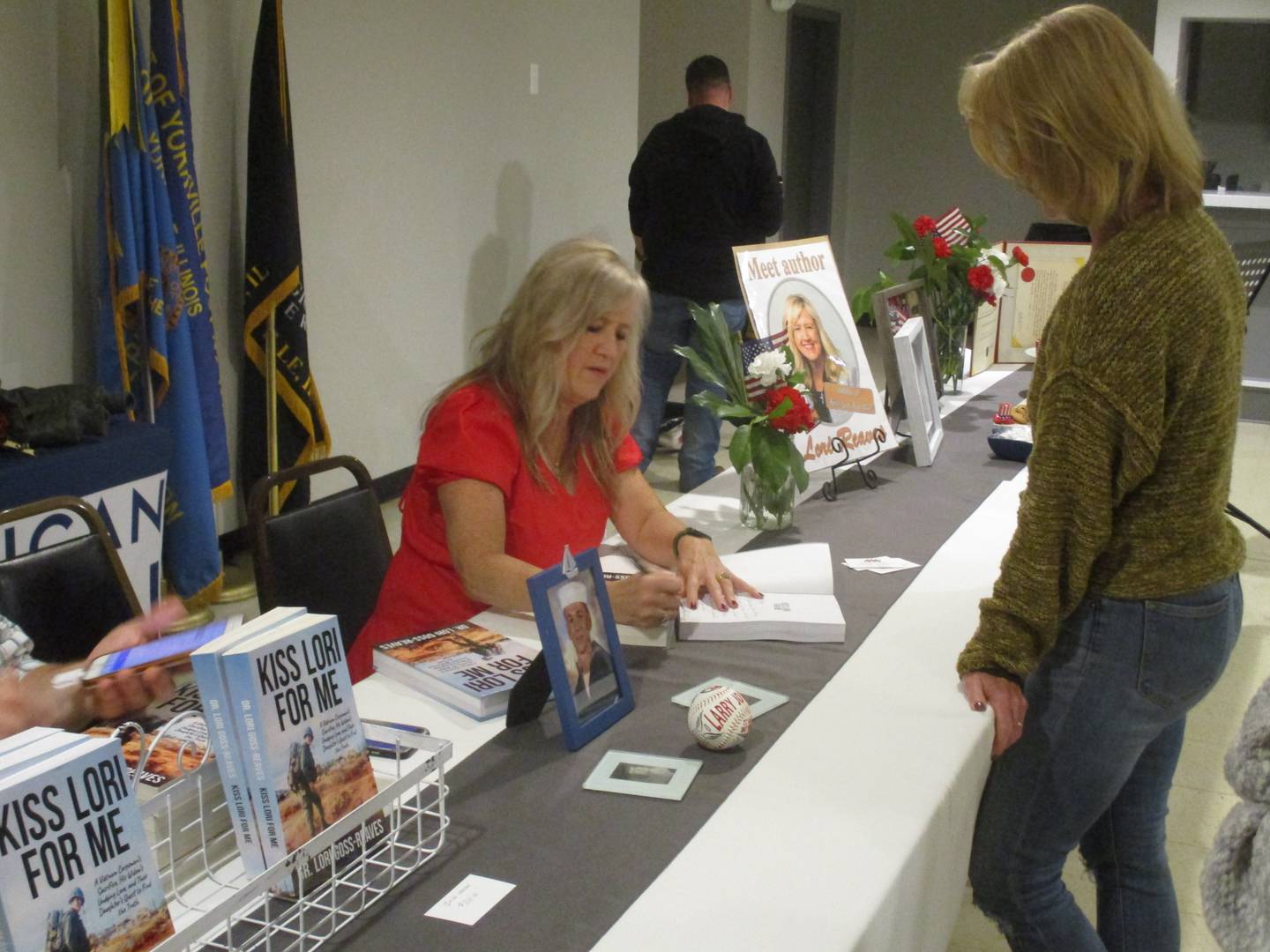 Author Lori Goss-Reaves signs a copy of her new book at Yorkville American Legion Post 489 on Sept. 11, 2022.