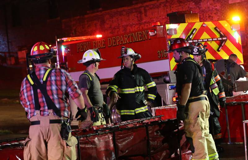 Firefighters fill tender boxes at Walnut and 5th Streets to fight a fire across from the Westclox building on Friday, July 14, 2023 in Peru. The fire began at 8:19p.m. A MABAS box alarm was issued to the fourth level and then brought back down after the fire was contained.