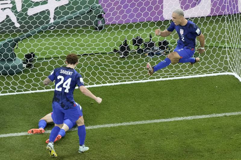 Sergino Dest of the United States, right, celebrates after teammate Christian Pulisic, on the ground, scored the opening goal during the World Cup group B soccer match between Iran and the United States at the Al Thumama Stadium in Doha, Qatar, Tuesday, Nov. 29, 2022. (AP Photo/Hassan Ammar)
