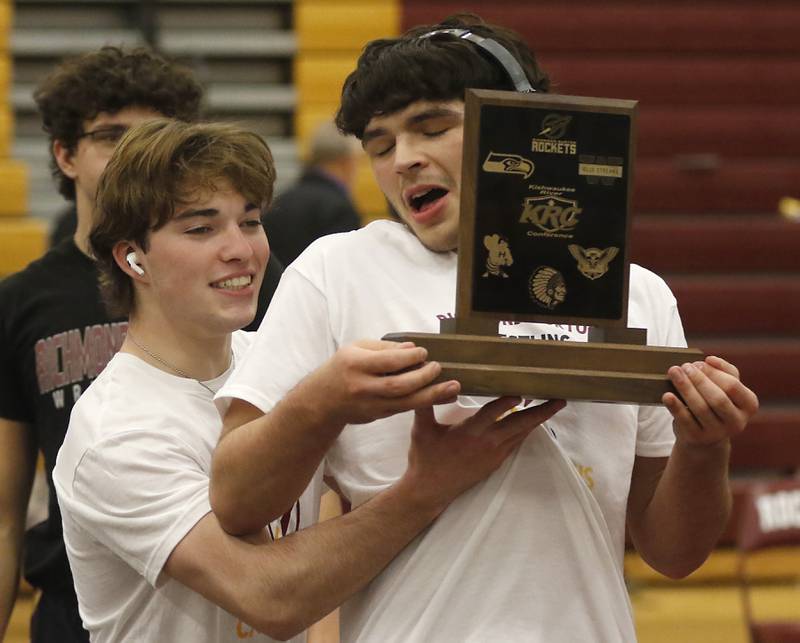 Richmond-Burton's Brody Rudkin jokes around with his teammate, Alex Reyna , as he hold the Kishwaukee River Conference wrestling trophy after Richmond-Burton defeated Johnsburg to win the conference title on Thursday, Jan. 25, 2024, at Richmond-Burton High School.
