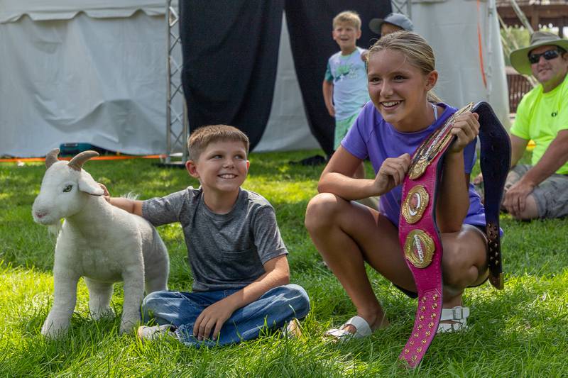 (left to right) Parker Corcoran smiles at sister Evelyn as she watches match at the Taste of the Illinois Valley DreamWave Wrestling event on Saturday, August 2, 2025 at Centennial Park in Peru.