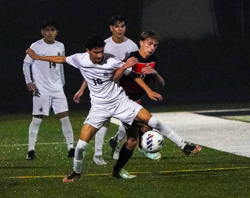 West Chicago's Ulices Huerta (18) challenges St. Charles East's Connor Sychowski (13) for the ball during a class 3A sectional semifinal soccer match at West Chicago High School on Wednesday, Oct. 25, 2023.