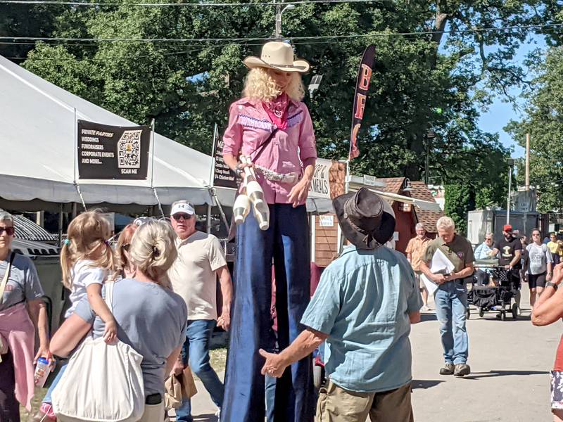 Carrie McQueen, known as the Ultimate Stilt Walker, greets visitors Sept. 4, 2024, at the Sandwich Fair.