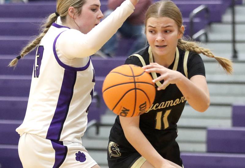 Sycamore’s Macy Calendo, right, dishes the ball past the coverage of Hampshire’s Autumn Kriegel in varsity girls basketball on Friday, Jan. 3, 2025, at Hampshire High School in Hampshire.