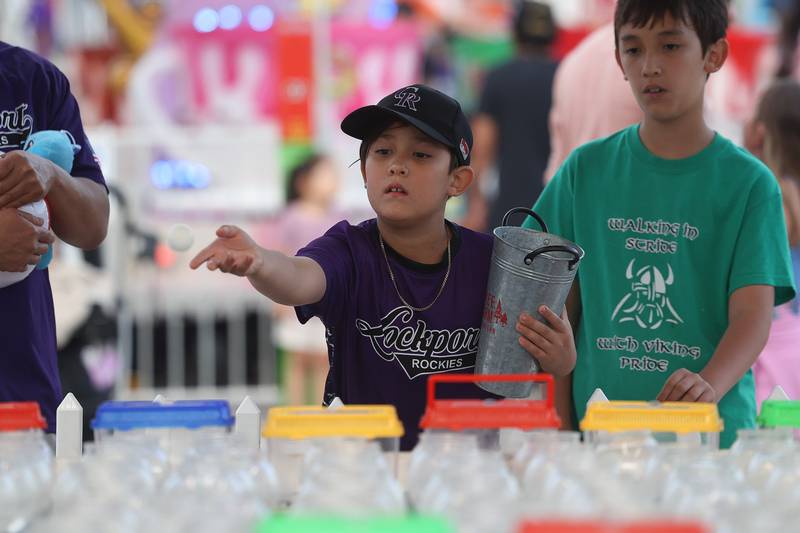 Colin Shim, with the Lockport Baseball organization, plays one of the carnival games at Old Canal Days on Friday June 7, 2024 in Lockport.