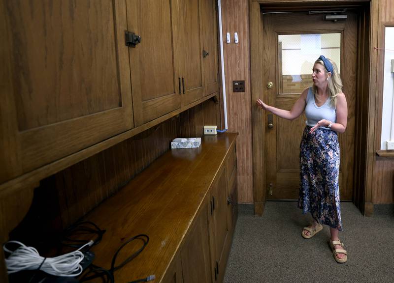 Lauren Holtz, director of communications and community engagement for Sycamore School District 427, talks Tuesday, June 18, 2025, about some of the original cabinetry at the former Central School in Sycamore. The nearly century old building currently houses the district offices but will soon be for sale. The district is hosting an open house at the building Saturday, June 21.