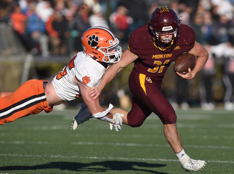 Joe Lewnard/jlewnard@dailyherald.com
Montini's Alex Marre, right, tries to break a tackle by Byron’s Everett Wichman during the Class 3A semifinal game in Lombard Saturday.