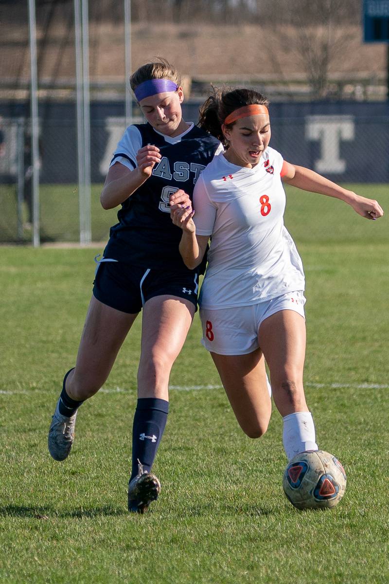 Oswego East's Emma Klosterman (9) challenges Oswego’s Natalie Braun (8) for the ball during a soccer match at Oswego East High School on Thursday, Apr 6, 2023.