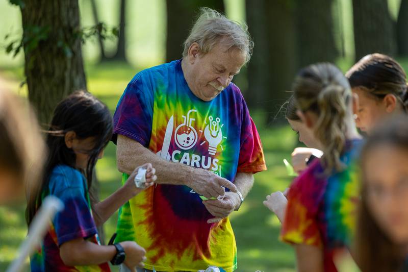 Counselor helps kids make paper rockets at the 23rd annual Carus Summer Science Camp on Friday, July 18, 2025 at St. Bede High School in Peru.