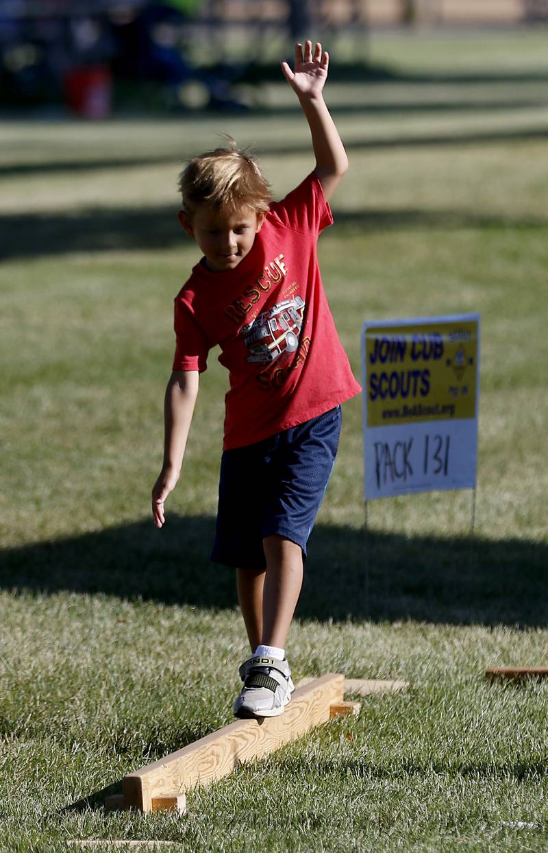 Benjamin Mitchell, 5, of McHenry tries a balance beam at the Cub Scout Pack 131 obstacle course during National Night Out! Tuesday, August 9, 2022, at Petersen Park in McHenry. The event was put on by the McHenry County Sheriff’s Office, City of McHenry Police Department and the McHenry County Conservation District and featured demonstrations, food and fun activities. National Night Out is held nationally in over 50,000 cities and is designed to help create relationships between neighbors and law enforcement community.