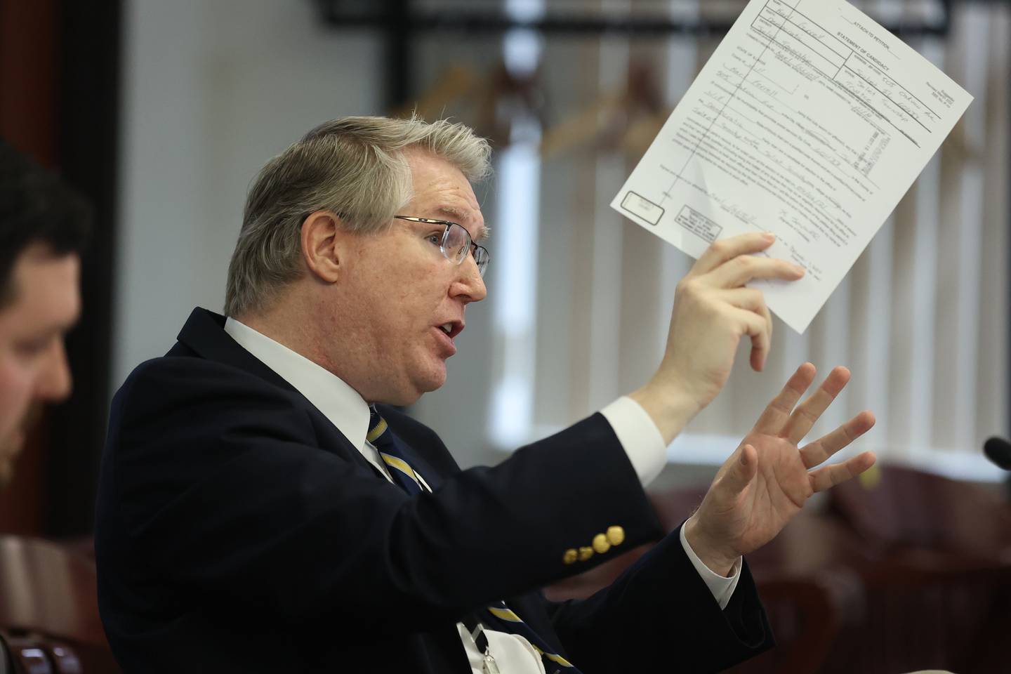 Prosecutor Scott Pyles holds up the Statement of Candidacy which prosecutor’s claim Karl Ferrell falsely filled out during the People v. Ferrell hearing at the Will County Annex building. Will County state’s attorneys are motioning to remove Joliet Township Trustee Karl Ferrell from the township board as they contend his past felony record disqualifies him from holding elected office. Tuesday, Mar. 30, 2022, in Joliet.