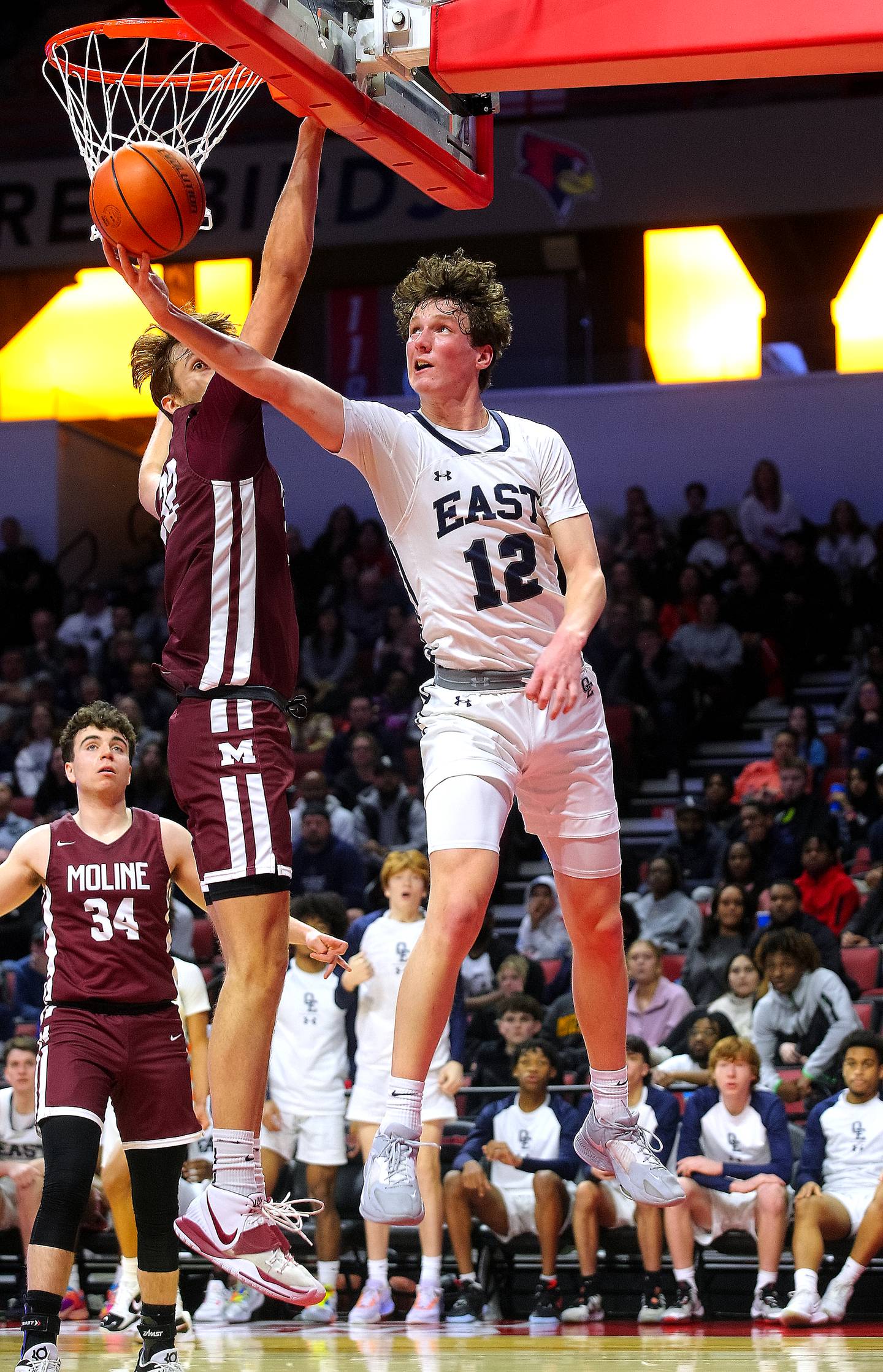 Oswego East's Ryan Johnson goes up for a reverse lay up around Moline's Trey Taylor during their supersectional game on Monday. The Wolves fell 59-55 to the Maroons ending this season Class 4A postseason run.    (Photo: PhotoNews Media/Clark Brooks)