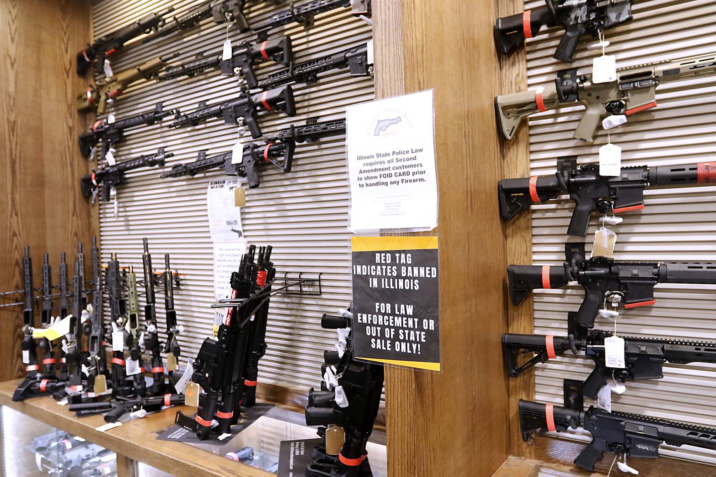 Red tagged firearms that can no longer sold at Second Amendment Sports, in McHenry, Wednesday Jan. 11, 2023, after a new gun law restricting a number of firearms and attachments and limiting ammunition was signed into law Tuesday night by Gov. JB Pritzker. The bill, along with requiring registration for such guns if already owned and enhancing gun restraining orders, hits at semiautomatic weapons.