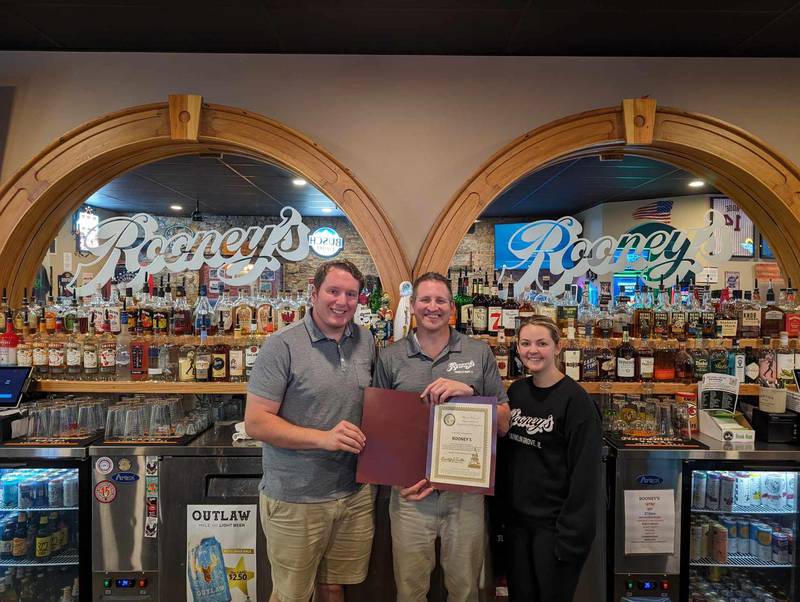 State Rep. Brad Fritts, left, presents Rooney's with a certificate declaring the business as his business highlight selection for May.