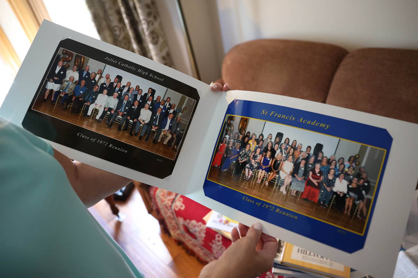 Marianne Wolf-Astrauskas is seen on Tuesday, Sept. 20, 2022, in Orland Park, holding the book distributed at her 50th reunion earlier in September. Wolf-Astrauskas created this 70-page book for the combined 50th reunion of the former Catholic High School and St. Francis Academy.