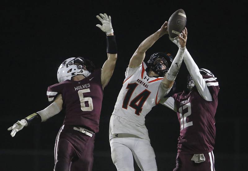 Crystal Lake Central's George Dimopoulos tries to catch a pass in-between the defense of Prairie Ridge's Luke Vanderwiel and Logan Thennes during a Fox Valley Conference football game on Friday, Oct. 13, 2023, at Prairie Ridge High School in Crystal Lake.