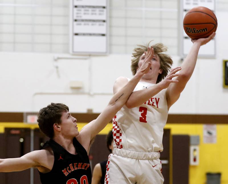 Huntley's Nathan Ary drives to the basket against McHenry’s Kayden Shatzer during a IHSA Class 4A Boys Regional basketball game Wednesday, Feb. 23, 2022, between Huntley and McHenry at Jacobs High School.