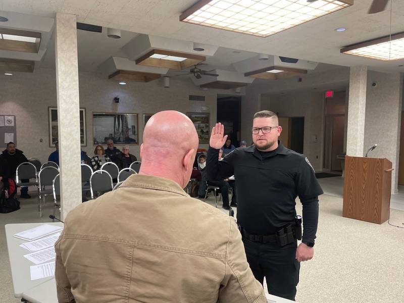 New Oglesby Police Officer Paul Petersen, hand raised, takes the oath of office from Commissioner Terry Eutis. Petersen is a lateral transfer from Mendota with experience in investigations.