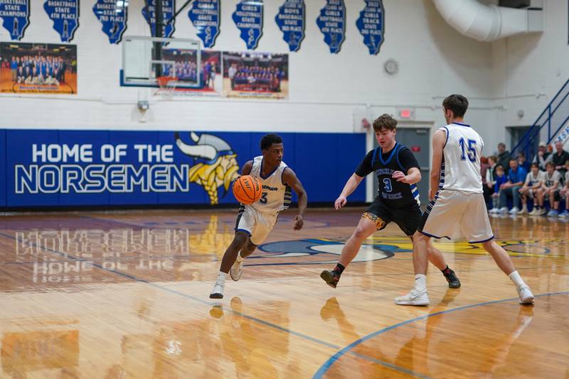 Newark’s Reggie Chapman (3) dibbles utilizing a pick by Payton Wills (15) against Hinckley-Big Rock's Austin Roop (3) during a basketball game at Newark High School on Tuesday, January 28, 2025.