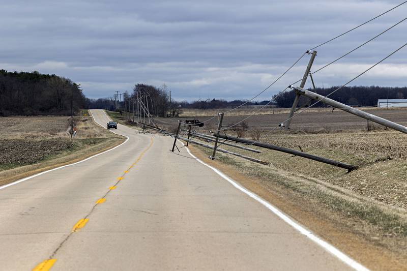 Downed power poles block a lane of traffic on Shaw Road outside of Amboy Saturday, April 1, 2023.