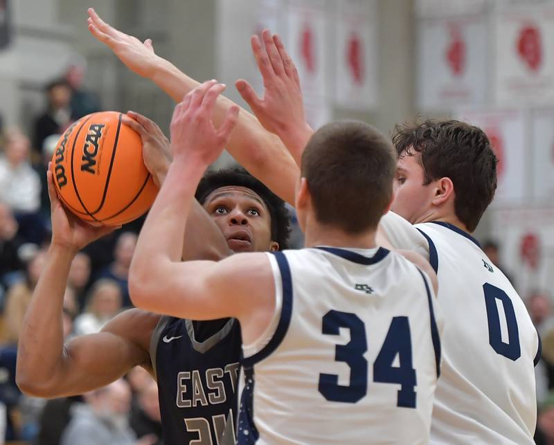 Oswego East’s Dshaun Bolden gets a peek at the basket through the arms of New Trier’s Denym Wallace (34) and Owen Foster during a When Sides Collide Shootout game on January 24, 2026 at Benet Academy in Lisle.