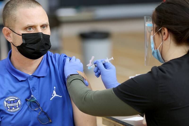 Woodstock High School Athletic Director Chris Kirkpatrick receives his first shot of the Moderna COVID-19 vaccine during a vaccination clinic for staff with Woodstock Community Unit School District 200 and Johnsburg School District 12 at Woodstock North High School on Thursday, Feb. 11, 2021 in Woodstock.  The clinic is hoping to vaccinate 2,600 employees of school districts in the northern half of McHenry County with the Moderna COVID-19 vaccine over the course of Thursday and Friday.