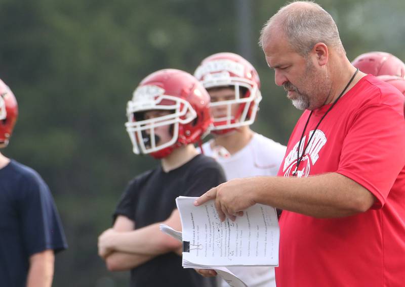Hall high school football coach Nick Sterling looks at his notes during camp on Thursday, July 24, 2025 at Hall High School.