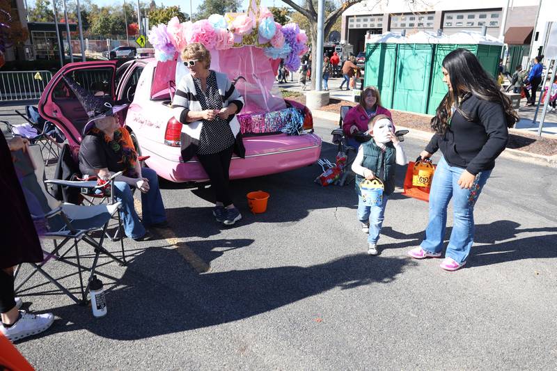 A family gets candy from the decorated Pink Heals vehicle at the Joliet Police Department Trunk-Or-Treat event on Saturday, Oct. 26, 2024 in Joliet.