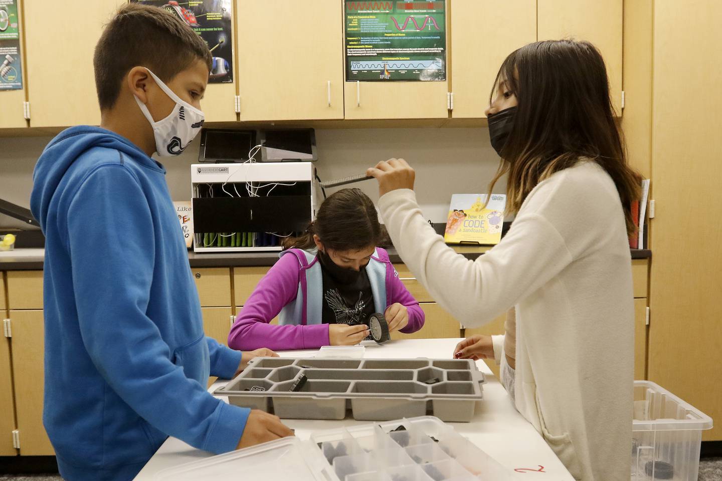 Coventry Elementary School fifth grade students (from left:) Julian Castillo, Sophia Muro, and Natasha Martinez-Barradas work on building a robotic vehicle from a Vex kit during in-person learning in STEM class with teacher Leslie Wise at Coventry Elementary School on Wednesday, Sept. 29, 2021 in Crystal Lake.  The new kits were available to use last year but using shared materials was not possible until this school year.