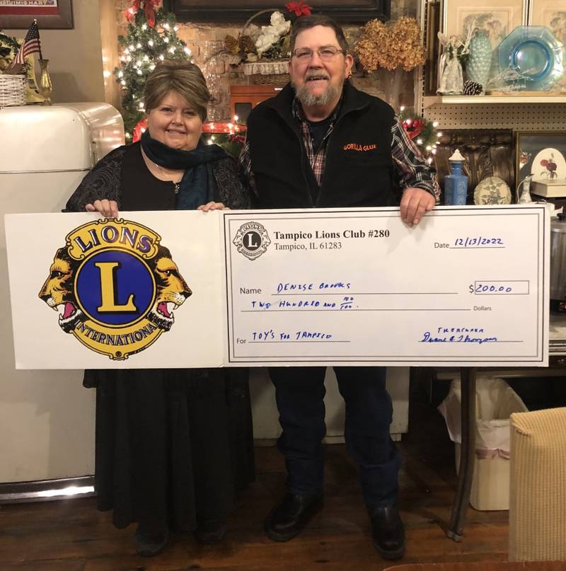 (Left to right); Toys for Tampico Coordinator Denise Brooks and Tampico Lions Club Treasurer Lion Duane Thompson donating a $200 check to Toys for Tampico Children.