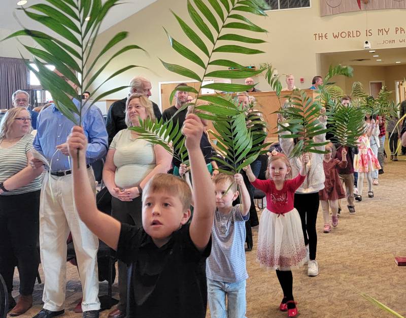 Children lead everyone in a celebration of waving  palms for Palm Sunday at Yorkville Trinity Church.