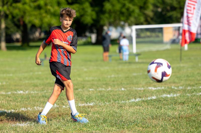 Griffin Clemens kicks the ball during a skills contest at the opening day ceremony of youth soccer on Saturday, Aug 16, 2025, at Peck Park in Ottawa.