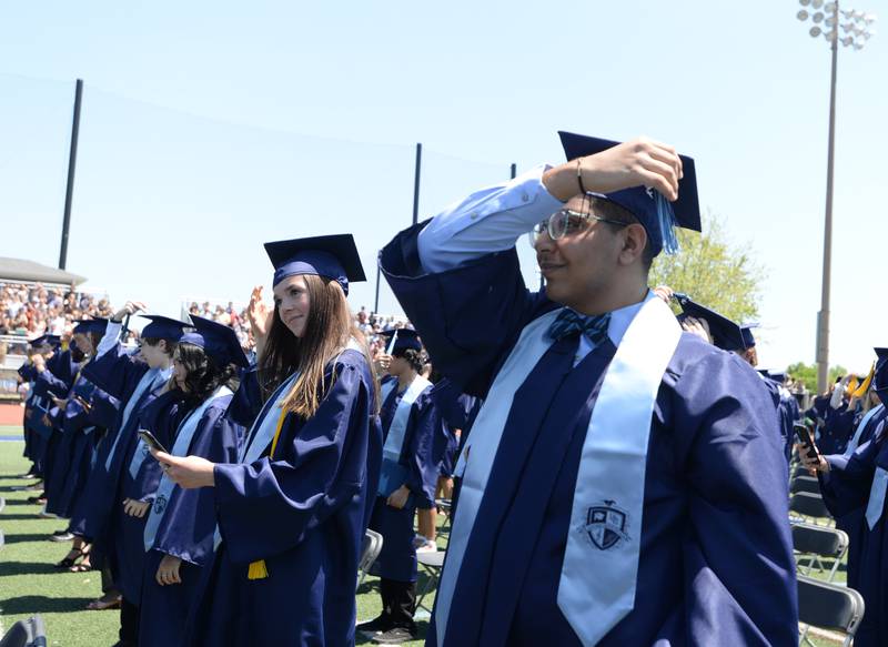 Downers Grove South graduates including John Mikhail switch the side of their tassel during the graduation ceremony Sunday May 21, 2023.