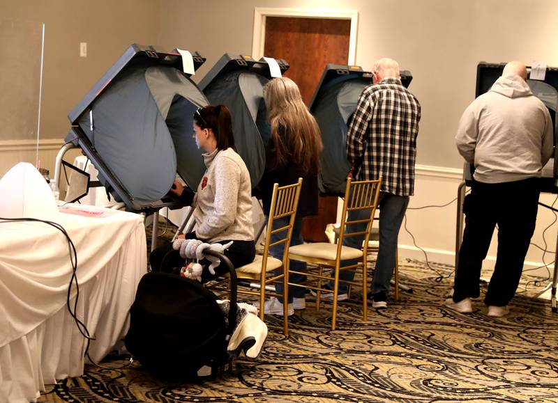 Nicole McLeaaren (far left), with her 3-month-old son, Clayton, votes in the General Election at the Lincoln Inn and Banquets in Batavia on Tuesday, Nov. 8, 2022.