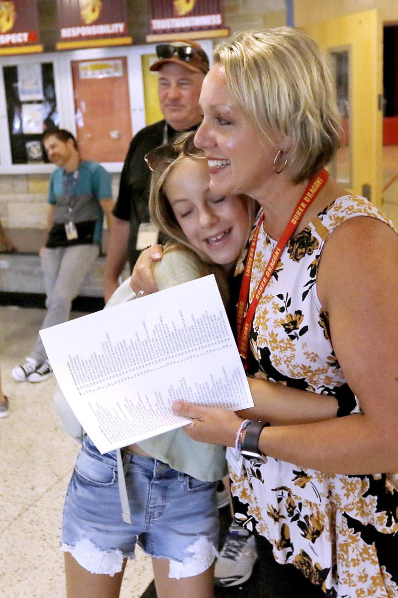 Fifth grader Skylar Burgdorf, 10, hugs Principal Lindsay Weber as she greets students and parents as they arrive at Duker Elementary School in McHenry, on Tuesday, Aug. 15, 2023, during school supplies drop-off day.