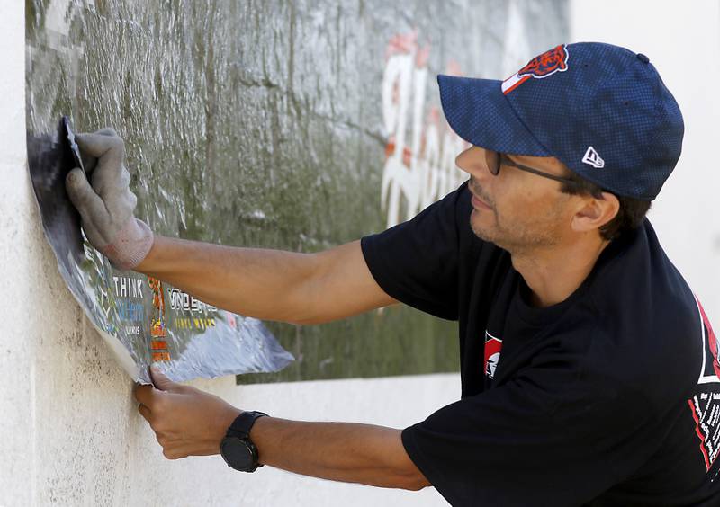 Chris Szymczuch, of Vindictive Vinyl, works on installing a vinyl mural on Thursday, June 19, 2025, on the side of a building at 3413 W. Elm St, in McHenry.