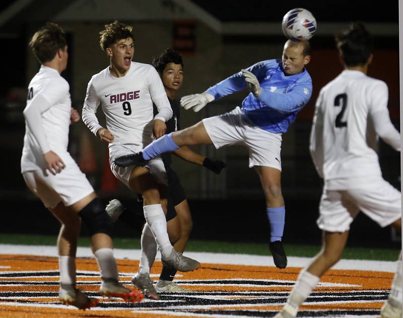 Prairie Ridge's Henry Knoll takes a shot hat goal as McHenry's Mason Bertone tries to defend the play during a Fox Valley Conference soccer match on Tuesday, Oct. 15, 2024, at McCraken Field in McHenry.