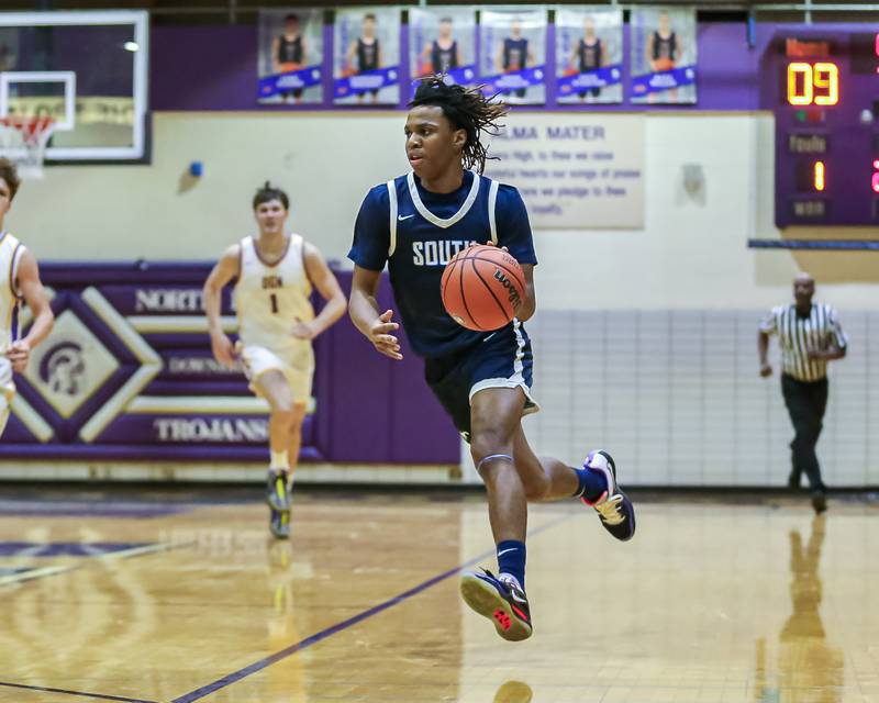 Downers Grove South's Keon Maggitt (1) drives to the basket during basketball game between Downers Grove South at Downers Grove North. Dec 16, 2023.
