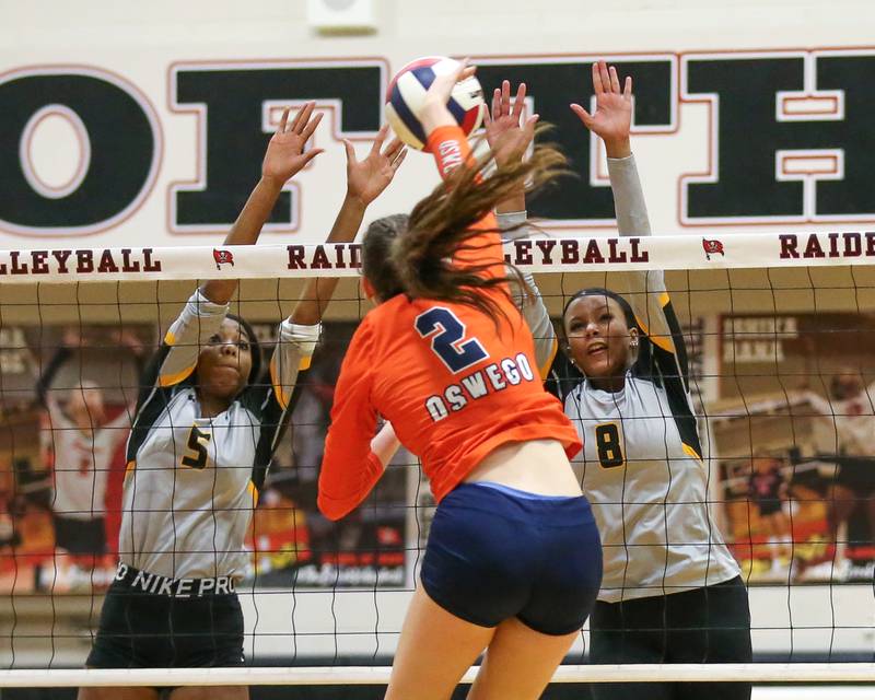 Joliet West's Mady Gant (5) and Eden Eyassu (8) attempt a block of Oswego's Kelsey Foster (2) spike during Class 4A Bolingbrook Sectional semifinal match between Joliet West at Oswego.  Nov 5, 2024  in Bolingbrook.