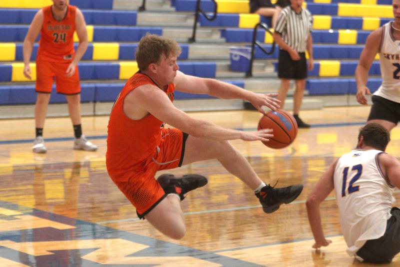 McHenry’s Jake Evans saves the ball from going out of bounds during an alumni basketball game at Johnsburg High School Saturday evening.