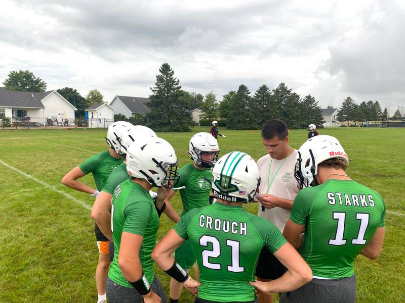 Dwight head coach Luke Standiford, second from right, goes over plays with his offense during the Trojans' home 7-on-7 with Streator on Tuesday, July 9, 2024.