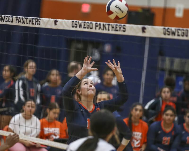 Oswego's Kimberly Reichard (15) sets a shot during volleyball match between Romeoville at Oswego. Oct 16, 2025.