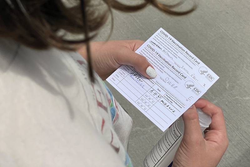 Jane Ellen Norman, 12, holds vaccination cards for her and her 14-year-old brother Owen outside Mercedes-Benz Stadium in Atlanta on Tuesday, May 11, 2021. The two were vaccinated Tuesday morning, after U.S. regulators expanded use of Pfizer's COVID-19 shot to those as young as 12. (AP Photo/Angie Wang)