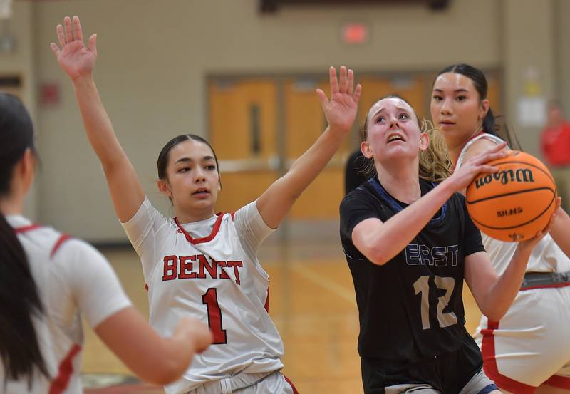 Oswego East’s Nicole Warbinski (12) goes to the basket as Benet’s Megan Sedillo (1) defends during the Class 4A Benet Regional final on February 19, 2026 at Benet Academy in Lisle.